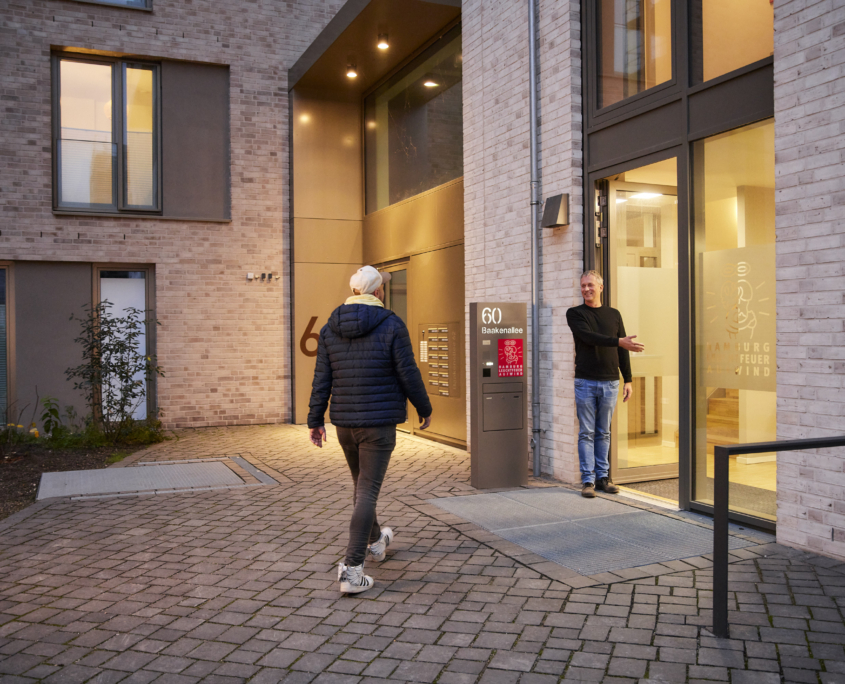 Aufwind-Mitarbeiter Thomas begrüßt einen Klienten an der Haustür von Aufwind.