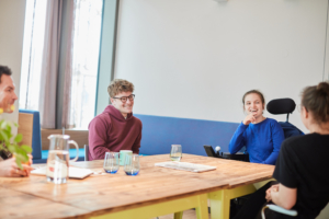 Bewohner*innen und Festland-Team gemeinsam im Gemeinschaftsraum