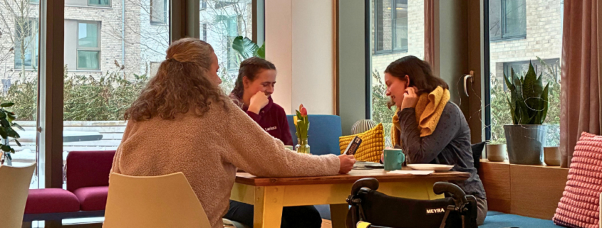 Drei Frauen sitzen bei Hamburg Leuchtfeuer Festland zusammen an meinem Tisch. Neben ihnen steht ein Rollstuhl.