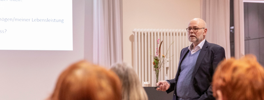 Rechtsanwalt Klaus Jakobsmeyer steht im Hamburg Leuchtfeuer Lotsenhaus vor eine Gruppe von Menschen und hält einen Vortrag.